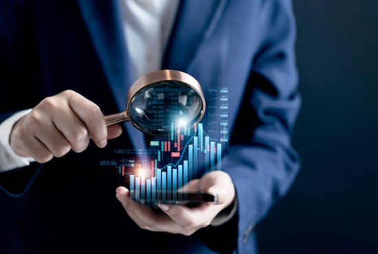бизнесмен с лупа, който гледа цифров индекс в дланта си